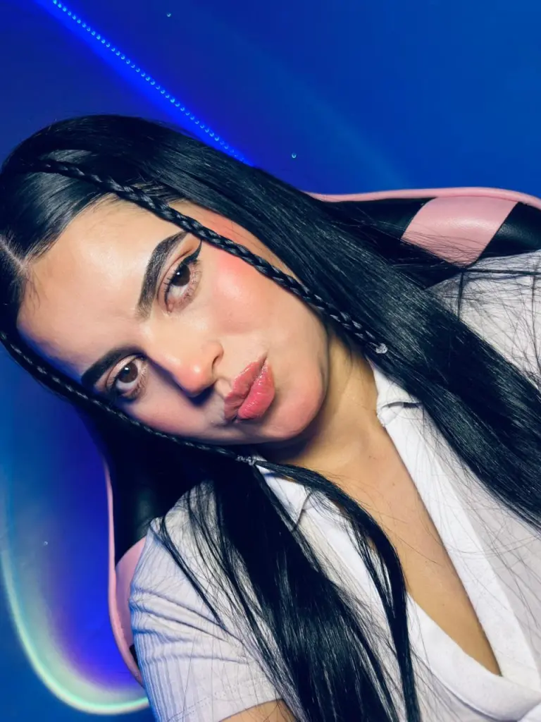 DaliaAprilx poses with a close-up headshot, showing her long dark hair and red lips against a dark background.