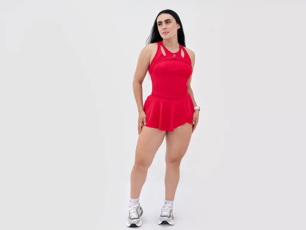 MeganBieck poses on the floor wearing a black cutout bodysuit with long dark hair.