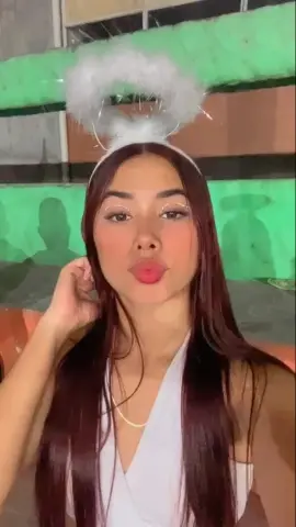 Young woman with long dark hair wearing a white angel headband and sleeveless top in a soft, dreamy mood.