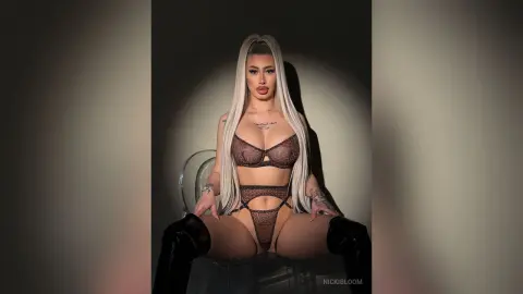 ViviAnne — NickiBloom sits on a clear chair wearing brown lace lingerie and black thigh-high boots.