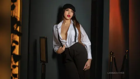 Stylish woman in white button-down shirt and black trousers posing confidently in moody indoor lighting.