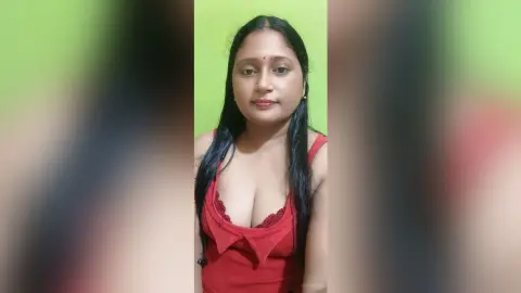 QueenPori looks at the camera wearing a red low-cut top against a lime green background.