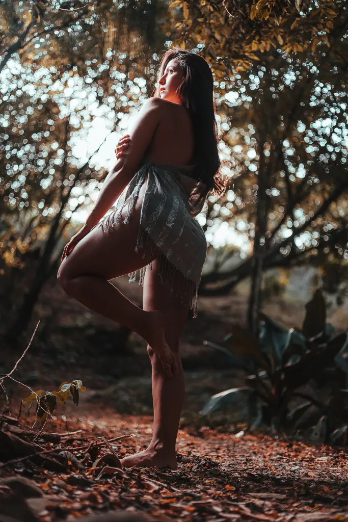 EvaPaoluci poses in a tight red dress against a dark background, looking at the camera with long dark hair.