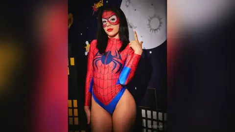 JessieLiu poses in a red and blue Spider-Man bodysuit with long black hair against a dark night-sky background.
