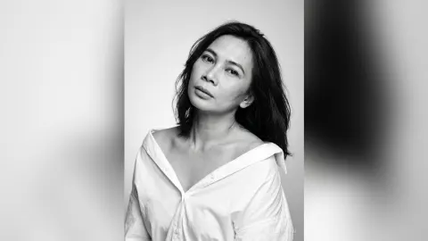 MilaSwan — MilaSwan poses in a white button-down shirt with her dark hair falling over her shoulders.
