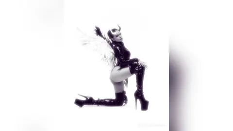 Woman in black latex bodysuit and devil horns posing in a dark fantasy cosplay outfit against a white background.