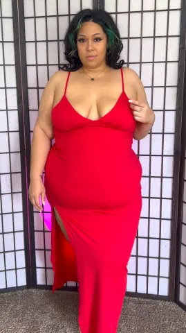 Curvy woman in a glamorous red evening gown posing against a shoji screen background.