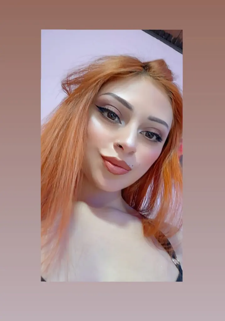 EmmilyWalkerr poses close-up with a white fuzzy headband, showing her face, long dark hair, and light makeup.