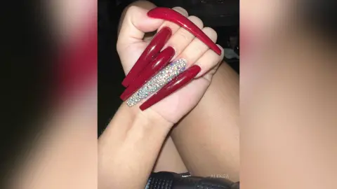 Long red stiletto nails with glitter accent design for a glamorous manicure look.