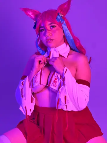 Cosplayer in red and white anime outfit posing under vibrant purple neon lighting.