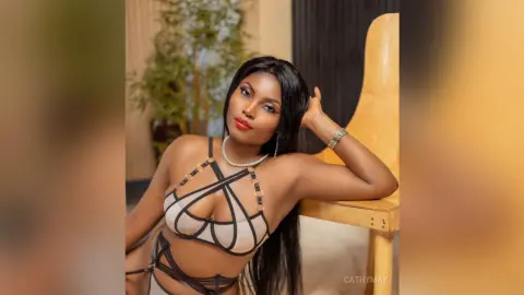 Beautiful woman in a stylish black and beige cutout lingerie set posing indoors with a confident mood.