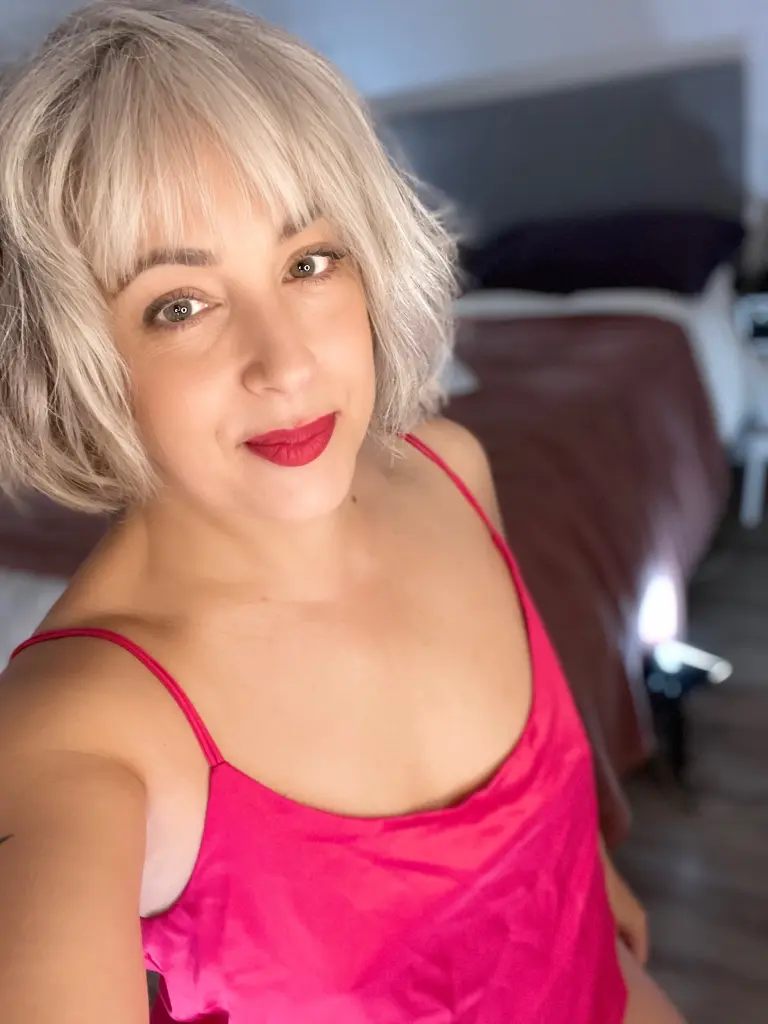 Seska looks directly at the camera with a neutral expression, showing her short grey hair and light makeup against a plain white background.
