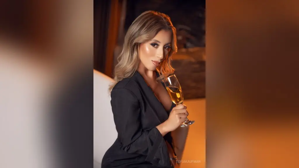 Glamorous woman in a sparkling silver bikini posing in a warm, wood-paneled luxury setting.