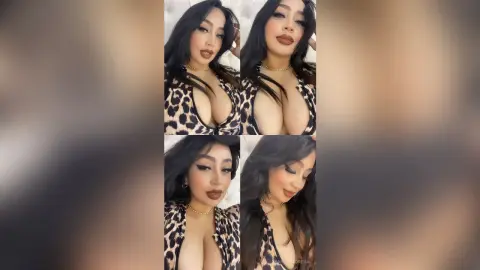 Glamorous woman in a leopard print top posing with long dark hair in a soft indoor setting.