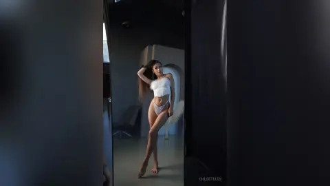 ChloeTeles poses in white lingerie, showing off her long hair and slim body in a modern room.