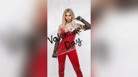 Blonde woman in a red dress and black gloves posing for a romantic Valentine's Day photoshoot.