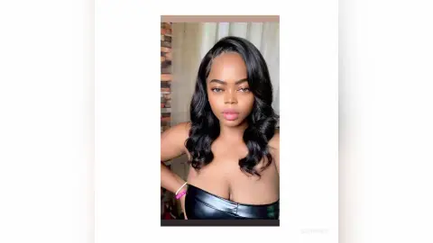 Beautiful Black woman in a black strapless top posing with a confident expression in a bright indoor setting.