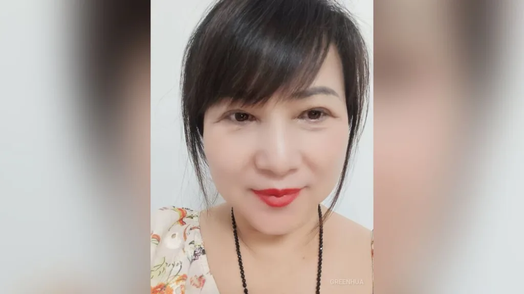 GreenHua — GreenHua looks into the camera with red lipstick and black hair in a floral top.