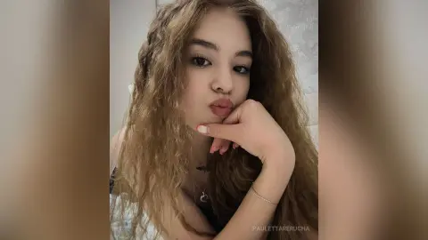PaulettaRerucha poses with her hand under her chin, showing her long wavy brown hair and dark eyes.