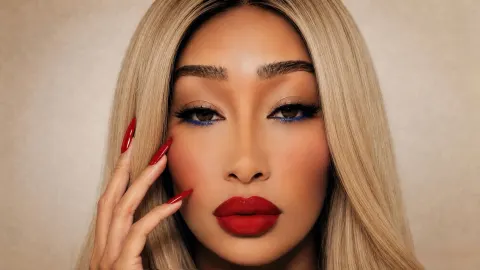 SOBLU — SOBLU poses with long red nails and blue eyeliner against a neutral background.