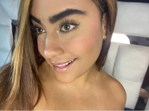 Smiling woman with glamorous makeup and long eyelashes posing for a close-up beauty portrait.