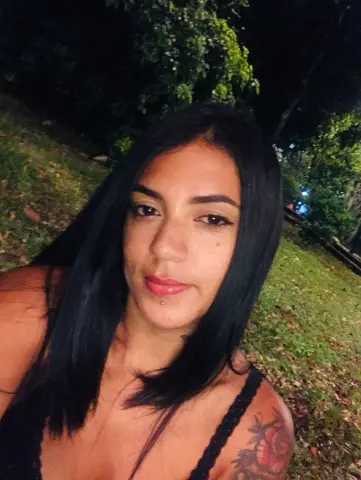 SusanaGlace shows her long black hair and shoulder tattoo while posing outdoors at night in a black lace top.
