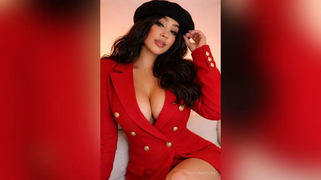 SharlinMoreva poses with long wavy black hair and bold red lipstick.
