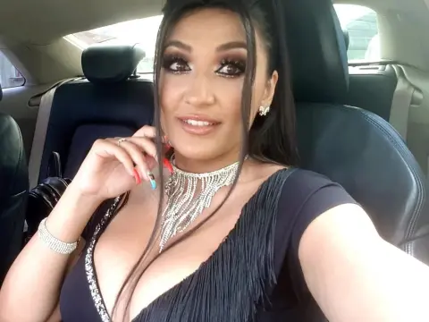 Alesya Nova — Alesya Nova wears a black fringed dress and a silver rhinestone choker while sitting in a car.
