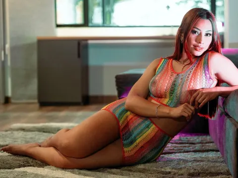 Gia Cavanna — Gia Cavanna reclines on a rug wearing a colorful rainbow lace lingerie set.