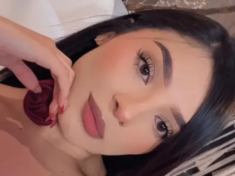 Mia Withe — Mia Withe poses for a close-up selfie with her hand near her face and dark hair framing her features.