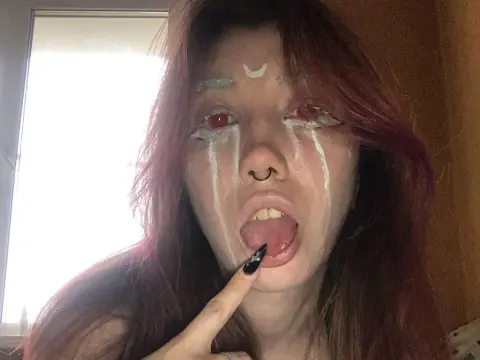 Runo Misaki — Runo Misaki sticks her tongue out while wearing white face paint and red contact lenses.