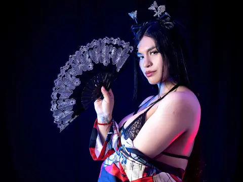 Greyssi Evans — Greyssi Evans poses in black lace lingerie while holding a large decorative fan against a dark background.