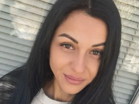 Eva Clarkk — Eva Clarkk smiles for a close-up selfie with her long black hair against window blinds.