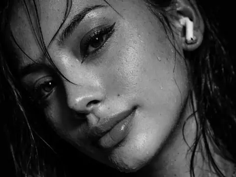 Gia Cavanna — Gia Cavanna looks into the camera with wet hair and a damp face in this black and white close-up.