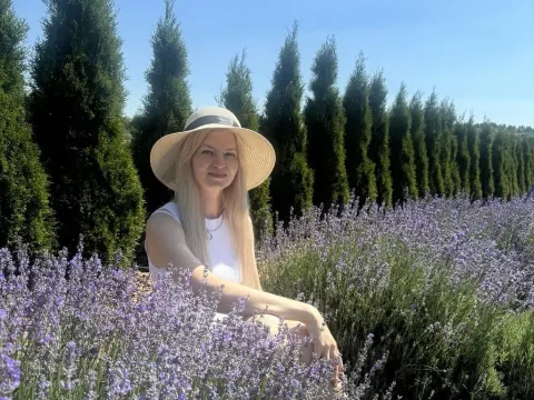 Melissa Tyler — Melissa Tyler wears a white sun hat and tank top while sitting in a field of purple lavender.