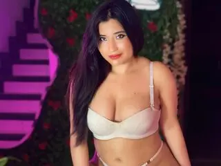Valentina Sweett — Valentina Sweett wears a white bra and poses in front of a floral background.