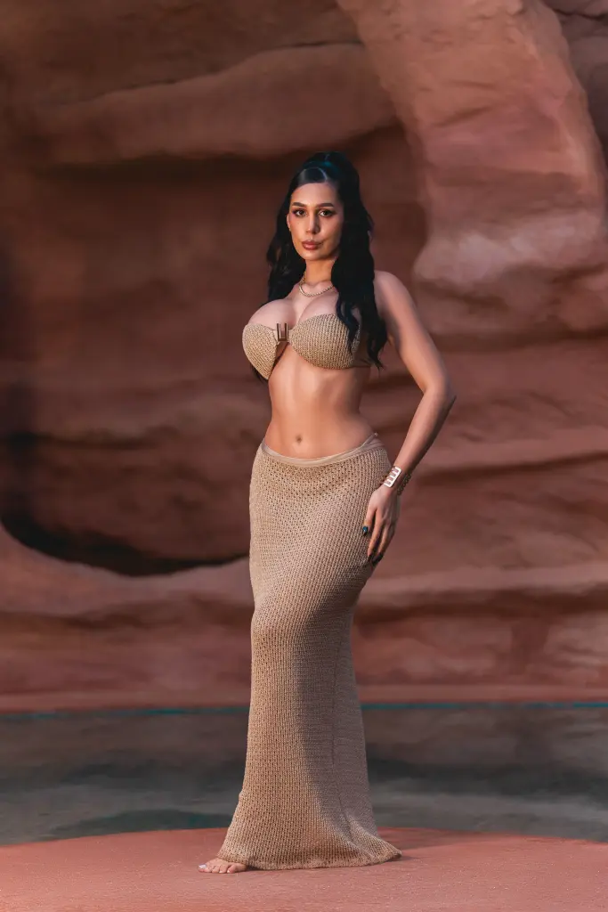 Glamorous woman in a beige bikini relaxing in a desert hot spring at sunset.