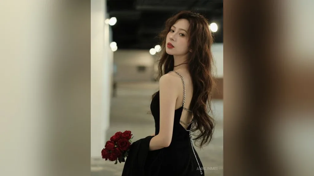 AnnLinMei — AnnLinMei poses in a black dress while holding a bouquet of red roses.