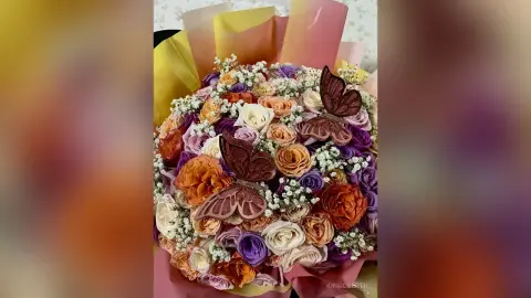 KimRoberth's colorful bouquet of roses and baby's breath decorated with large brown butterfly ornaments.