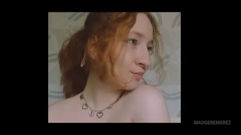 MadgeRemerez shows her face and shoulders, wearing a heart-pendant necklace with her reddish-brown hair pulled back in a loose ponytail.