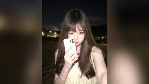 TessaMabel — TessaMabel takes a selfie at night wearing a yellow floral top while standing outdoors.