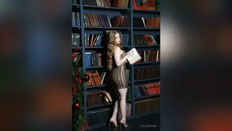 Elegant woman in a gold sequin dress reading a book in a moody, dark library setting.