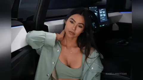 Young woman in a sage green outfit relaxing inside a modern car with a calm mood.