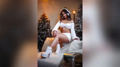 Glamorous woman in a white fuzzy two-piece outfit and boots posing in a cozy winter wonderland setting.