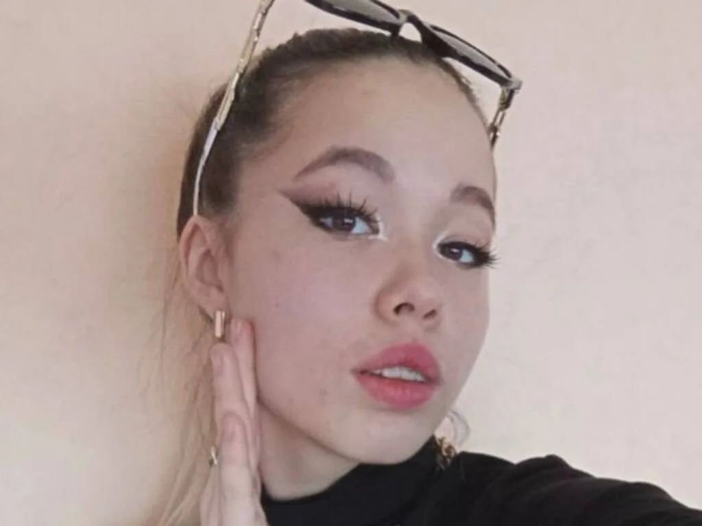 SteffaniePons poses with her hand against her cheek, wearing black clothing and sunglasses on top of her head.