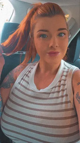 SavanahRosexxx — SavanahRosexxx is a redhead in a striped tank top sitting in a car.
