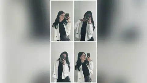 Young woman in a white blazer and black top taking mirror selfies in a minimalist indoor setting.
