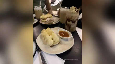 Delicious cream puffs and iced coffee served on a cafe table for a cozy dessert snack time.