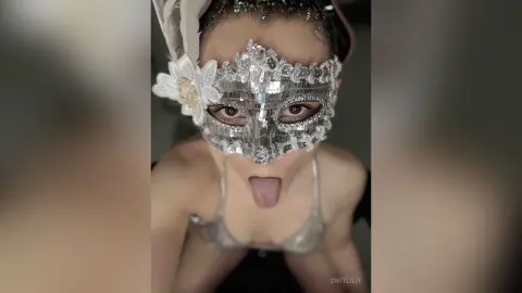 Glamorous woman in a sparkling silver masquerade mask and sequined outfit for a mysterious carnival mood.
