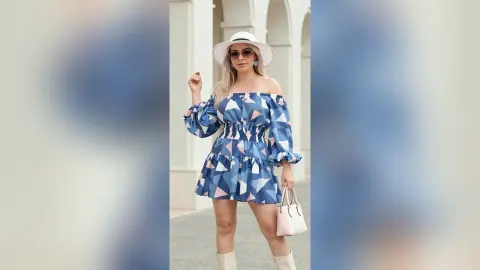 Stylish woman in a blue patterned off-the-shoulder mini dress and white sun hat posing outdoors in summer fashion.